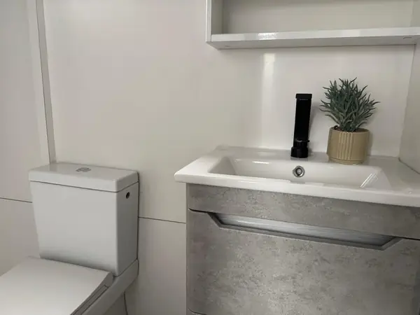 RAGAN – badrum med handfat, spegel och WC