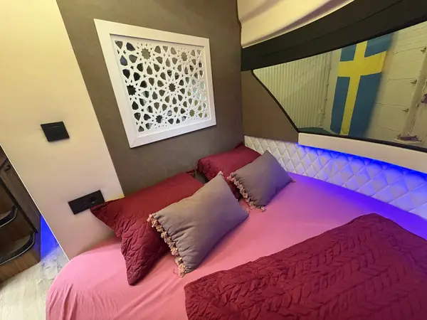Dubbelsäng med rundad gavel och läslampor